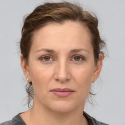 Joyful white adult female with medium  brown hair and grey eyes