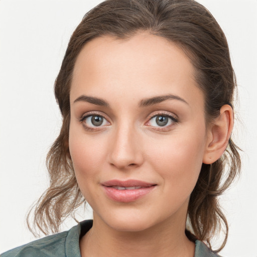 Joyful white young-adult female with medium  brown hair and grey eyes