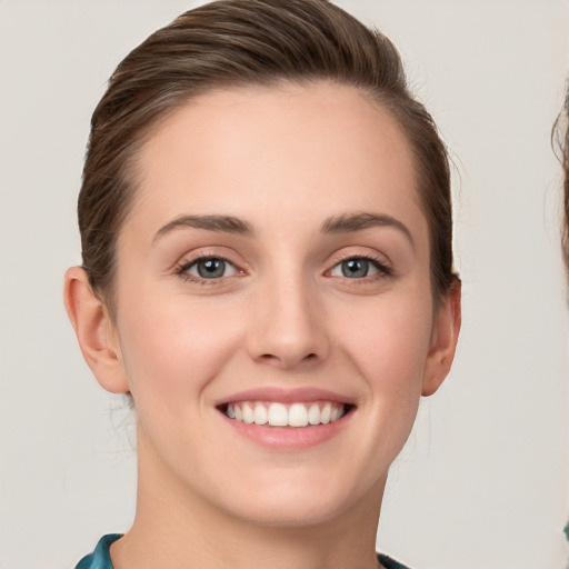 Joyful white young-adult female with short  brown hair and grey eyes