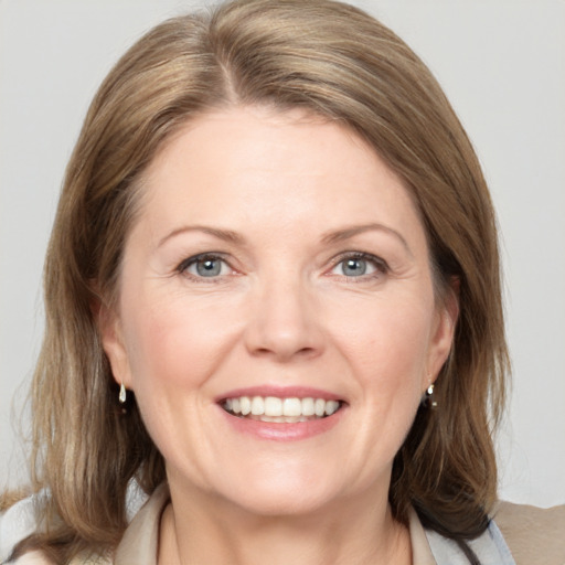 Joyful white adult female with medium  brown hair and blue eyes