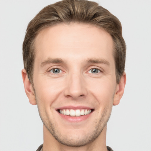 Joyful white young-adult male with short  brown hair and grey eyes