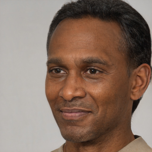 Joyful black adult male with short  brown hair and brown eyes