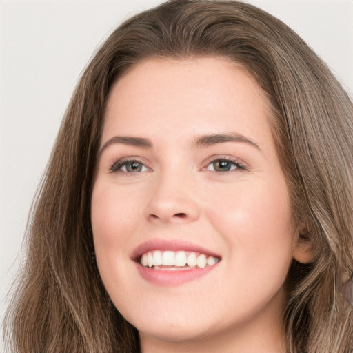 Joyful white young-adult female with long  brown hair and green eyes