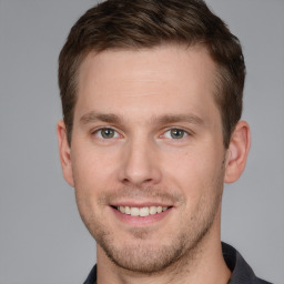 Joyful white young-adult male with short  brown hair and grey eyes