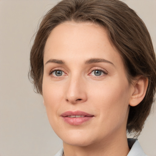 Joyful white young-adult female with medium  brown hair and green eyes