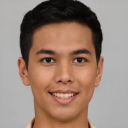 Joyful latino young-adult male with short  brown hair and brown eyes