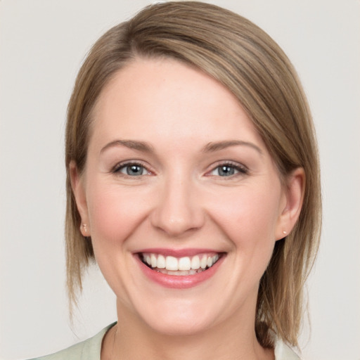 Joyful white young-adult female with medium  brown hair and green eyes