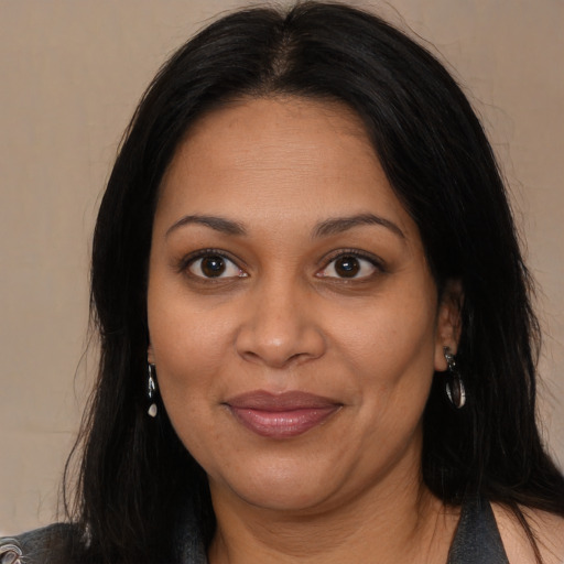 Joyful black adult female with long  brown hair and brown eyes