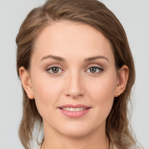 Joyful white young-adult female with medium  brown hair and grey eyes