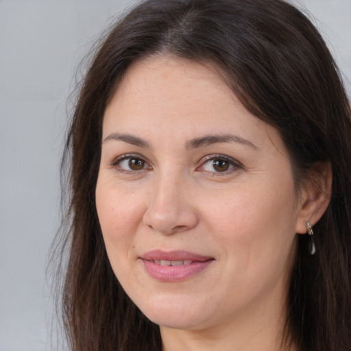 Joyful white adult female with long  brown hair and brown eyes