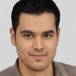 Joyful latino young-adult male with short  brown hair and brown eyes