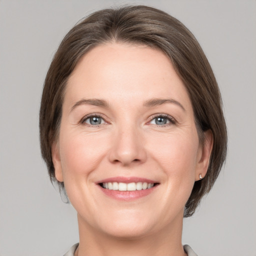 Joyful white adult female with medium  brown hair and grey eyes