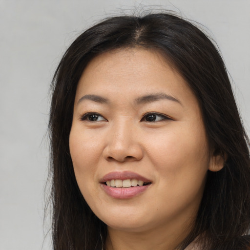 Joyful asian young-adult female with long  brown hair and brown eyes