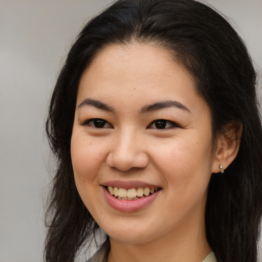 Joyful latino young-adult female with long  brown hair and brown eyes