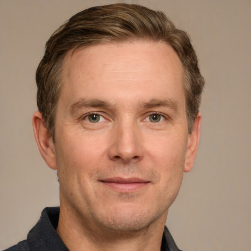 Joyful white adult male with short  brown hair and grey eyes