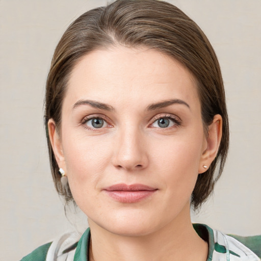 Joyful white young-adult female with medium  brown hair and green eyes