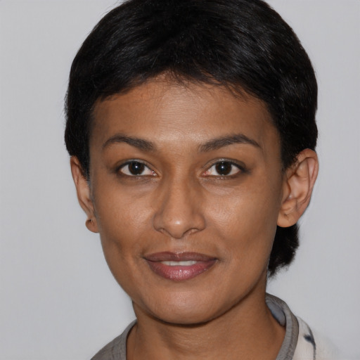 Joyful black young-adult female with short  brown hair and brown eyes