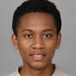 Joyful black young-adult male with short  brown hair and brown eyes