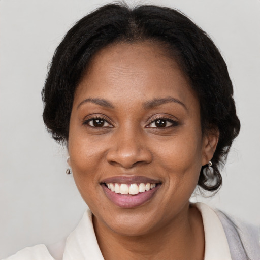 Joyful black adult female with medium  brown hair and brown eyes