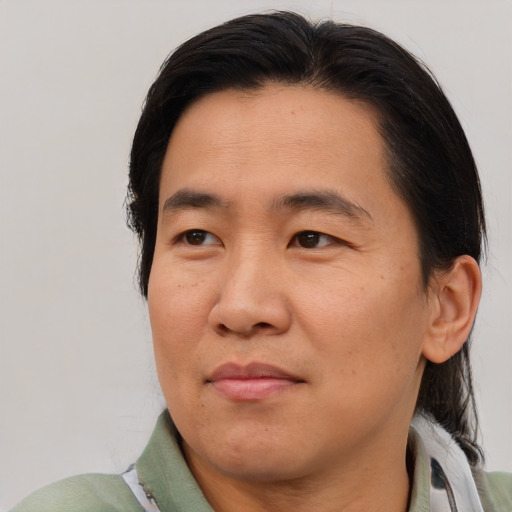 Joyful asian adult male with short  brown hair and brown eyes
