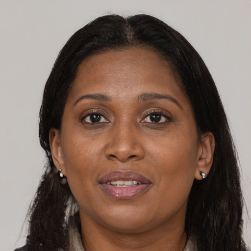 Joyful black adult female with long  brown hair and brown eyes