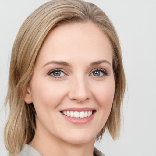 Joyful white young-adult female with medium  brown hair and blue eyes