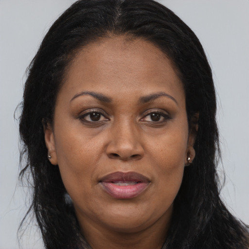 Joyful black adult female with long  brown hair and brown eyes