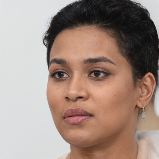 Joyful latino young-adult female with short  black hair and brown eyes
