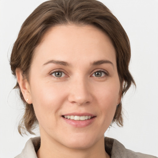 Joyful white young-adult female with medium  brown hair and grey eyes