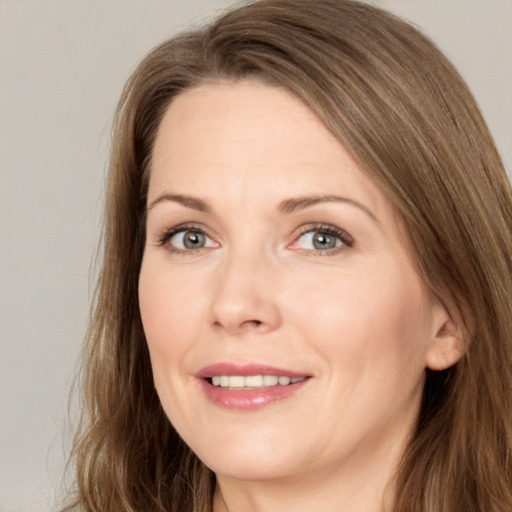 Joyful white adult female with long  brown hair and brown eyes