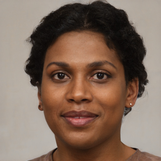 Joyful black young-adult female with short  brown hair and brown eyes