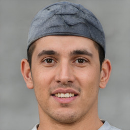 Joyful white young-adult male with short  black hair and brown eyes