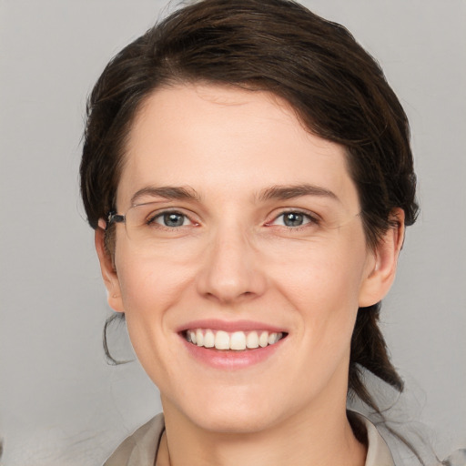 Joyful white young-adult female with medium  brown hair and grey eyes