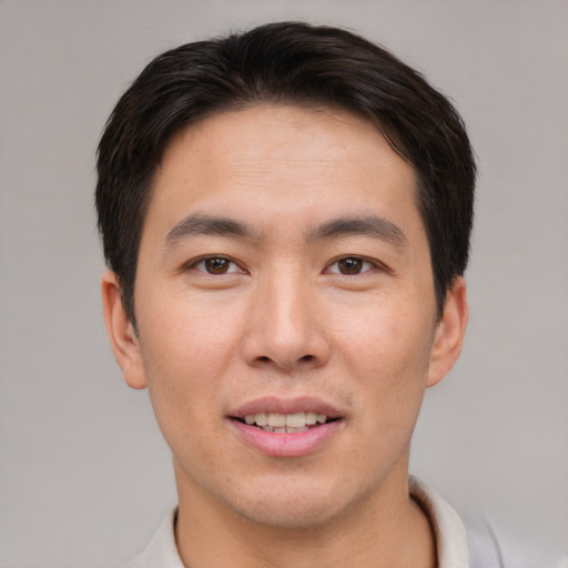 Joyful asian young-adult male with short  brown hair and brown eyes
