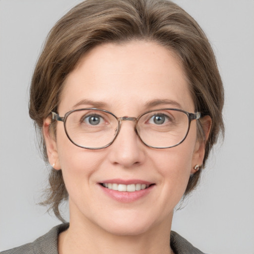 Joyful white adult female with medium  brown hair and grey eyes