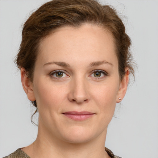 Joyful white young-adult female with medium  brown hair and green eyes