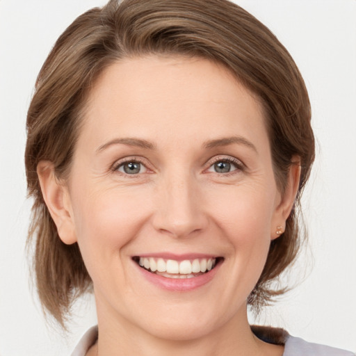 Joyful white adult female with medium  brown hair and grey eyes