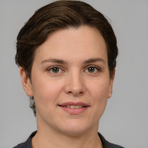 Joyful white young-adult female with short  brown hair and grey eyes