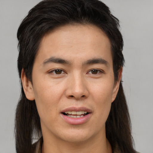 Joyful white young-adult male with long  brown hair and brown eyes