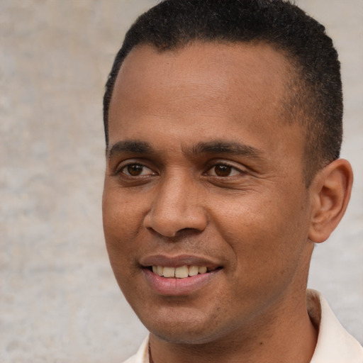 Joyful black young-adult male with short  brown hair and brown eyes