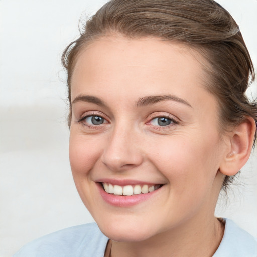 Joyful white young-adult female with medium  brown hair and blue eyes