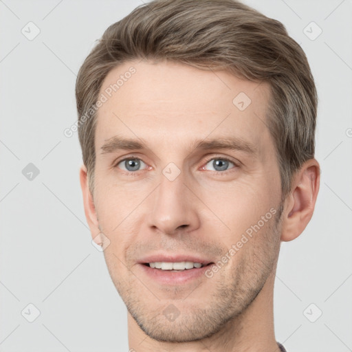 Joyful white young-adult male with short  brown hair and grey eyes