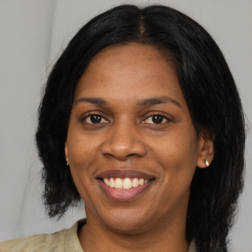Joyful black adult female with long  black hair and brown eyes