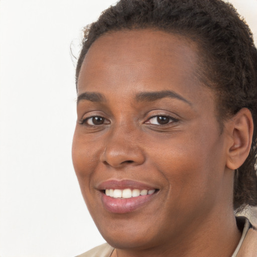 Joyful black young-adult female with long  brown hair and brown eyes