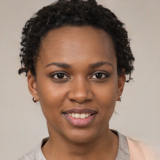 Joyful black young-adult female with short  brown hair and brown eyes