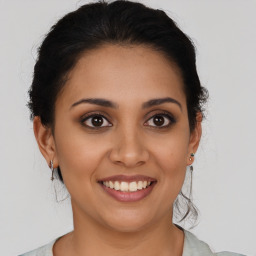 Joyful latino young-adult female with medium  brown hair and brown eyes