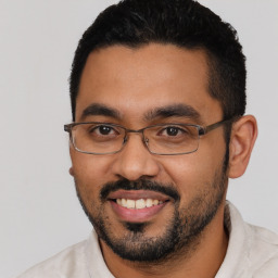 Joyful latino young-adult male with short  black hair and brown eyes