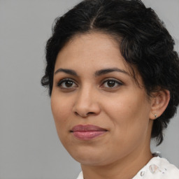 Joyful latino adult female with medium  brown hair and brown eyes