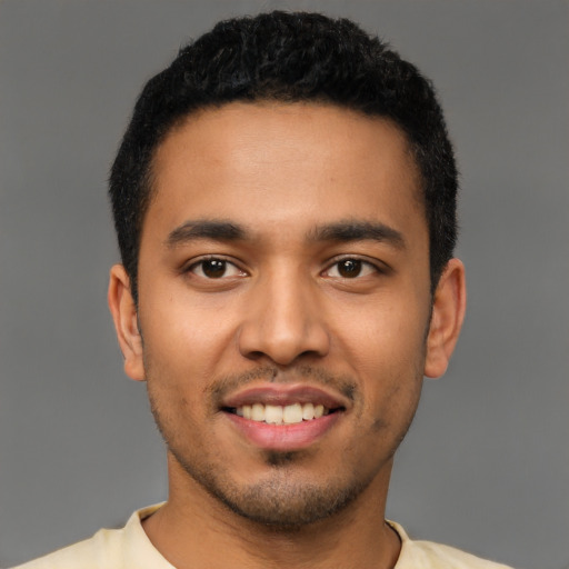 Joyful latino young-adult male with short  black hair and brown eyes