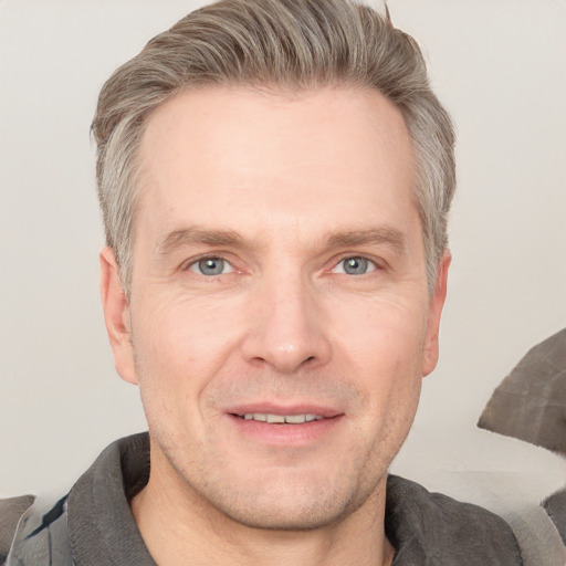 Joyful white adult male with short  brown hair and grey eyes